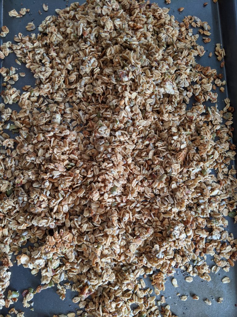 The cooked Wholesome Maple Nut Breakfast Granola cooling on a baking tray