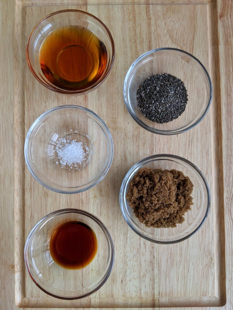 The other ingredients (maple syrup, chia seeds, salt, brown sugar and vanilla extract) on a chopping board, ready to make Wholesome Maple Nut Breakfast Granola