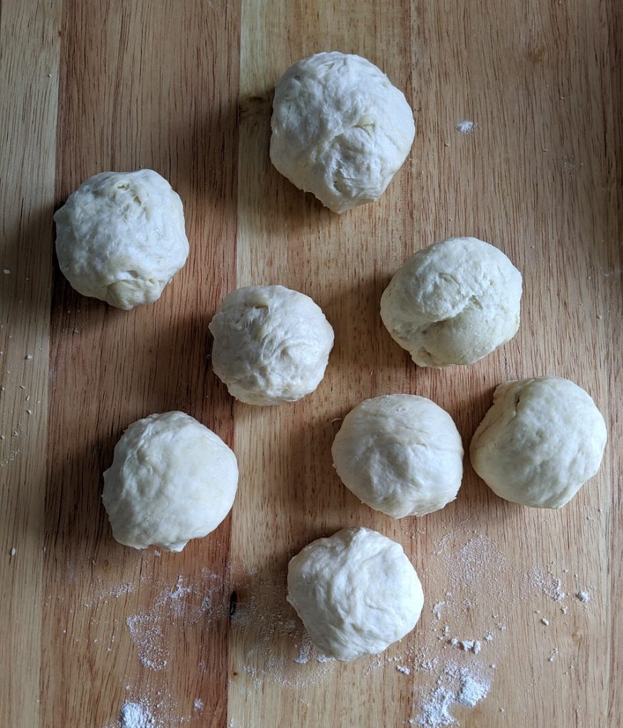 Homemade tortilla dough divided into eight pieces
