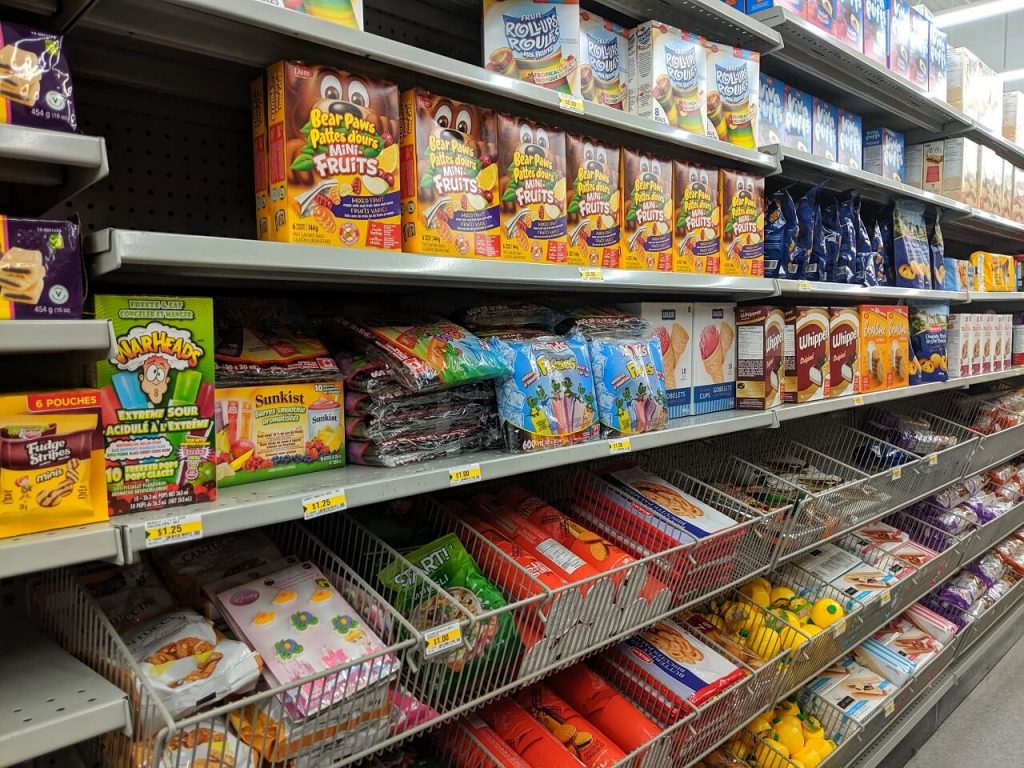 Side view of cookie aisle at dollar store, with different packets of cookies on shelves