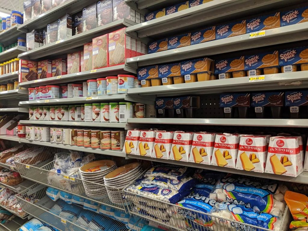 Side view of shelves in dollar store, with baking items like icing and sugar